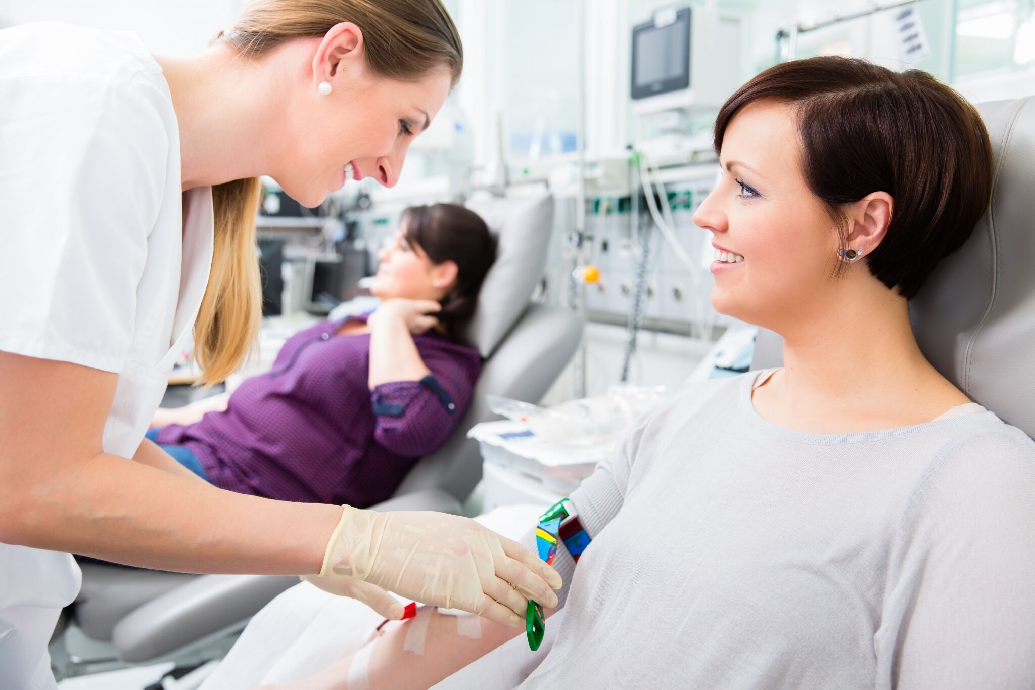 Female nurse performing blood transfusion.