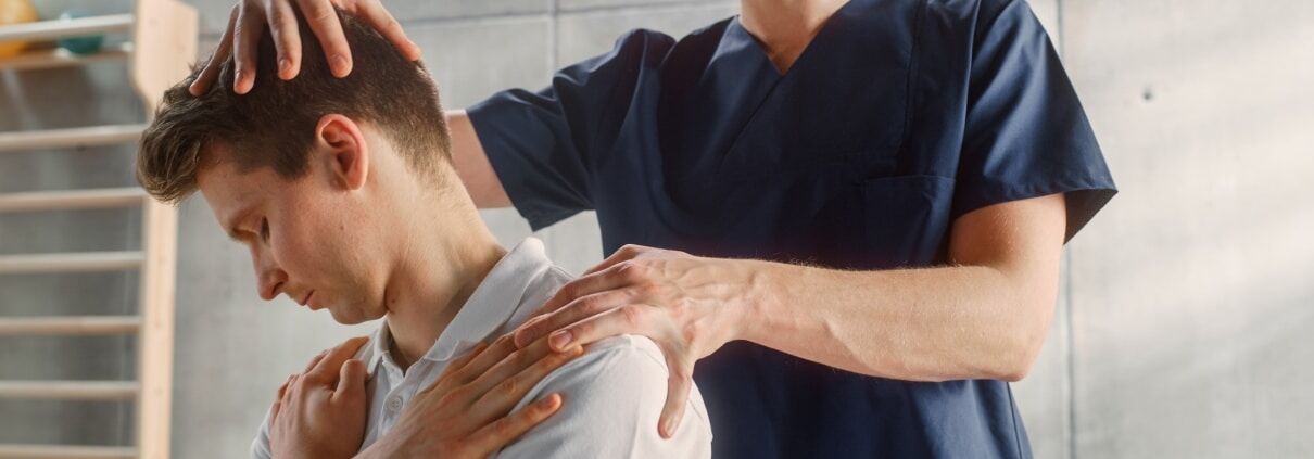 Physical therapy professional examining a man